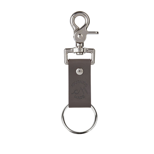 grey travel keyring made of leather on a white background