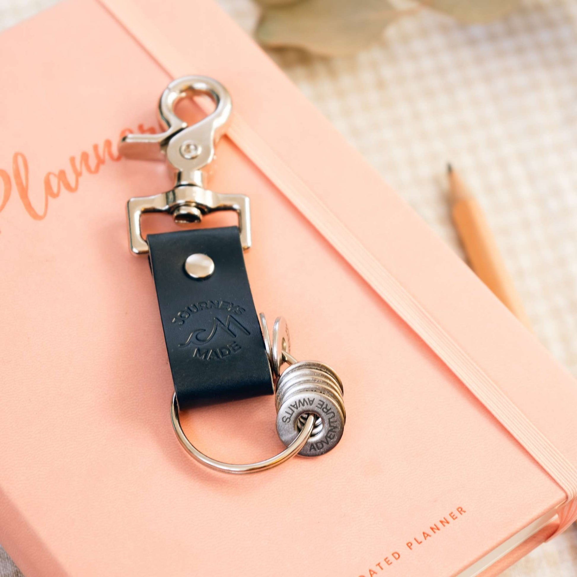 Ocean blue leather travel keyring on a planner, perfect for travel gifts and keepsakes.