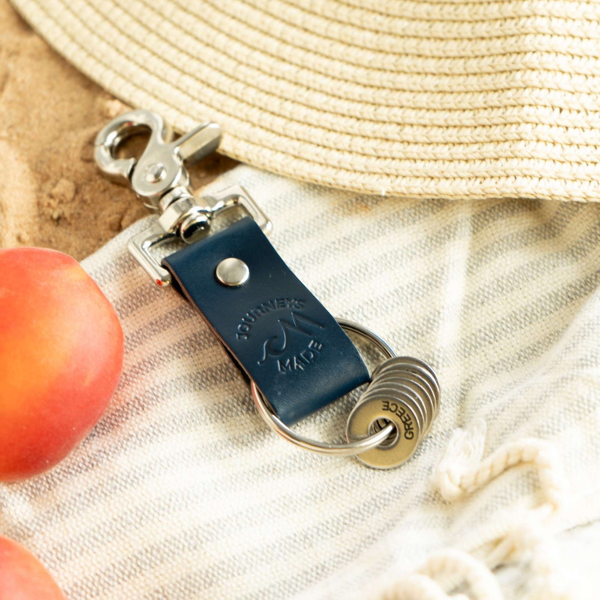 Ocean blue leather travel keyring with engraved tokens, perfect for unique travel gifts and keepsakes.