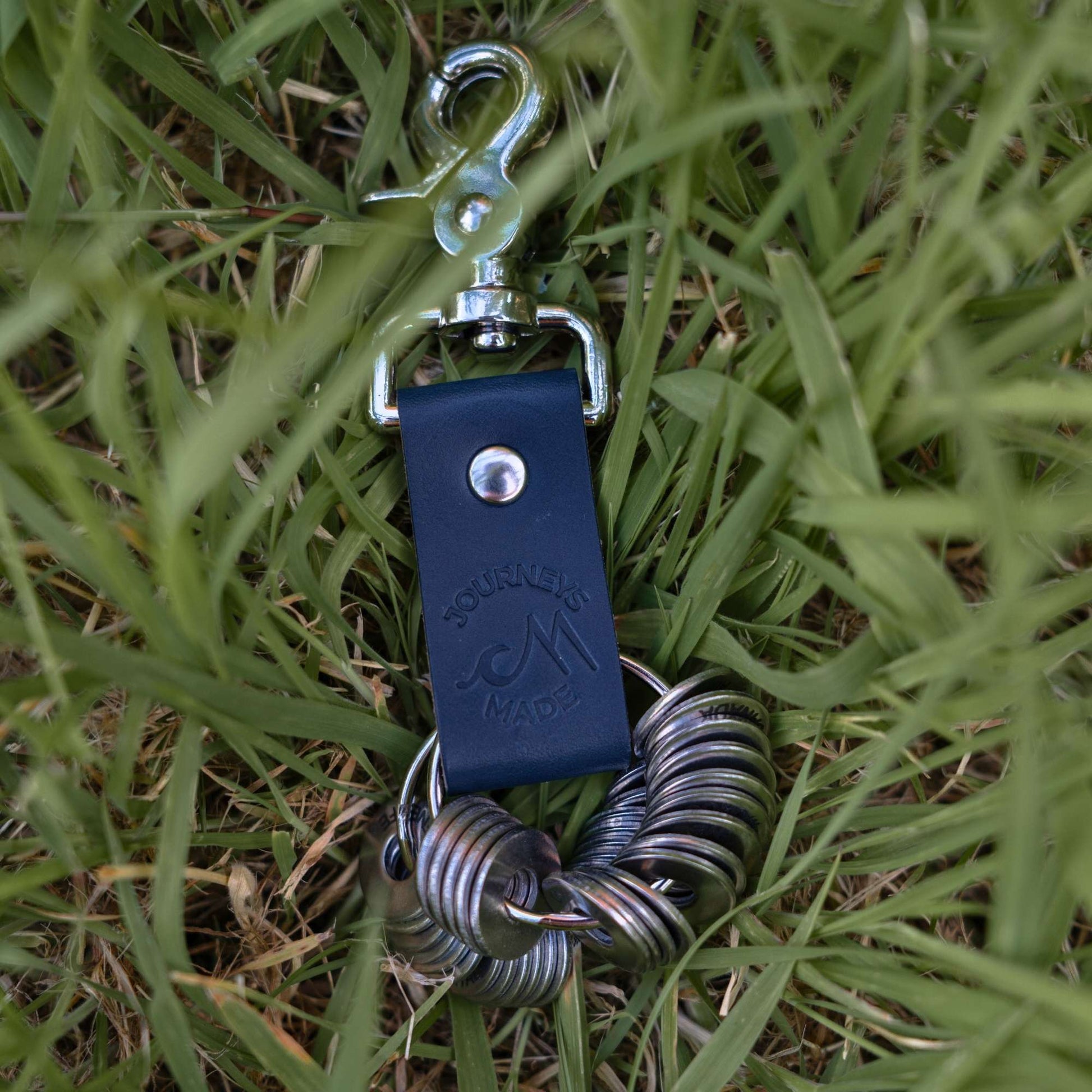 Handcrafted ocean blue leather travel keyring with metal clip, perfect for travel gifts.