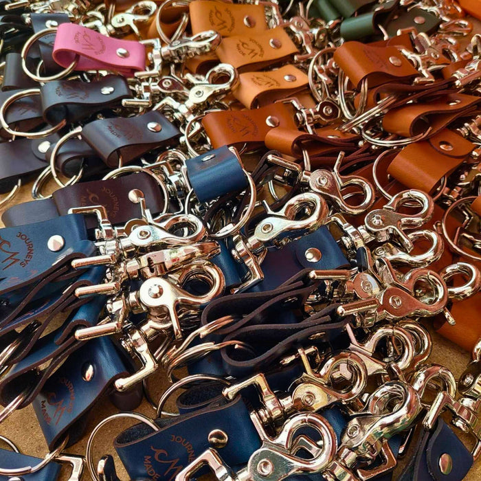 bulk custom branded leather keychains as event gifts for corporates, keychain colours are tan, forest green, pink, ocean blue, black and dark brown