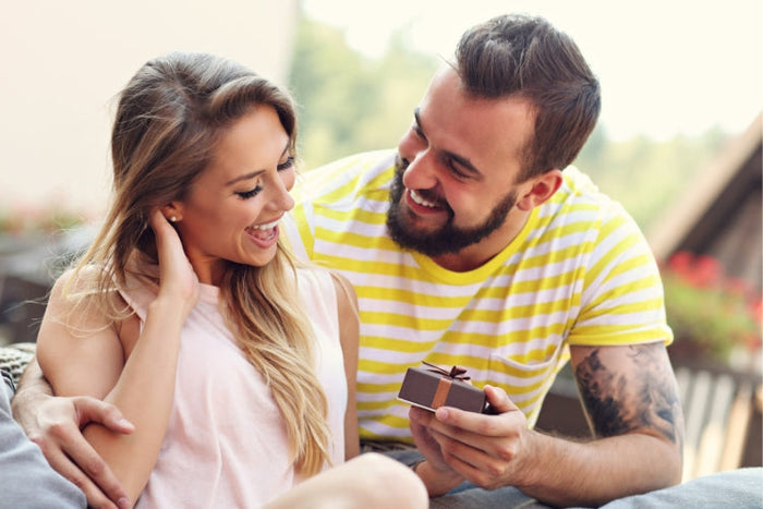 Couple celebrating a special occasion with a gift, showcasing joy and love while enjoying their time together.