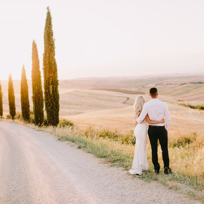 newlywed couple in Tuscany looking at the rolling hills at sunset