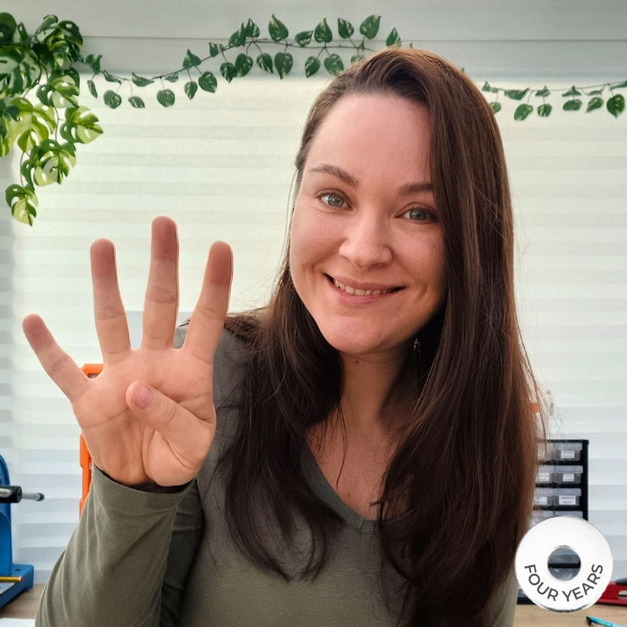 Jade Scammells founder of Journeys Made, a white woman with brown hair holding up 4 fingers to symbolise the 4th anniversary of the business.