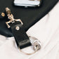 Close-up of a handcrafted black leather travel keychain attached to a travel bag, ideal for travel gift sets.