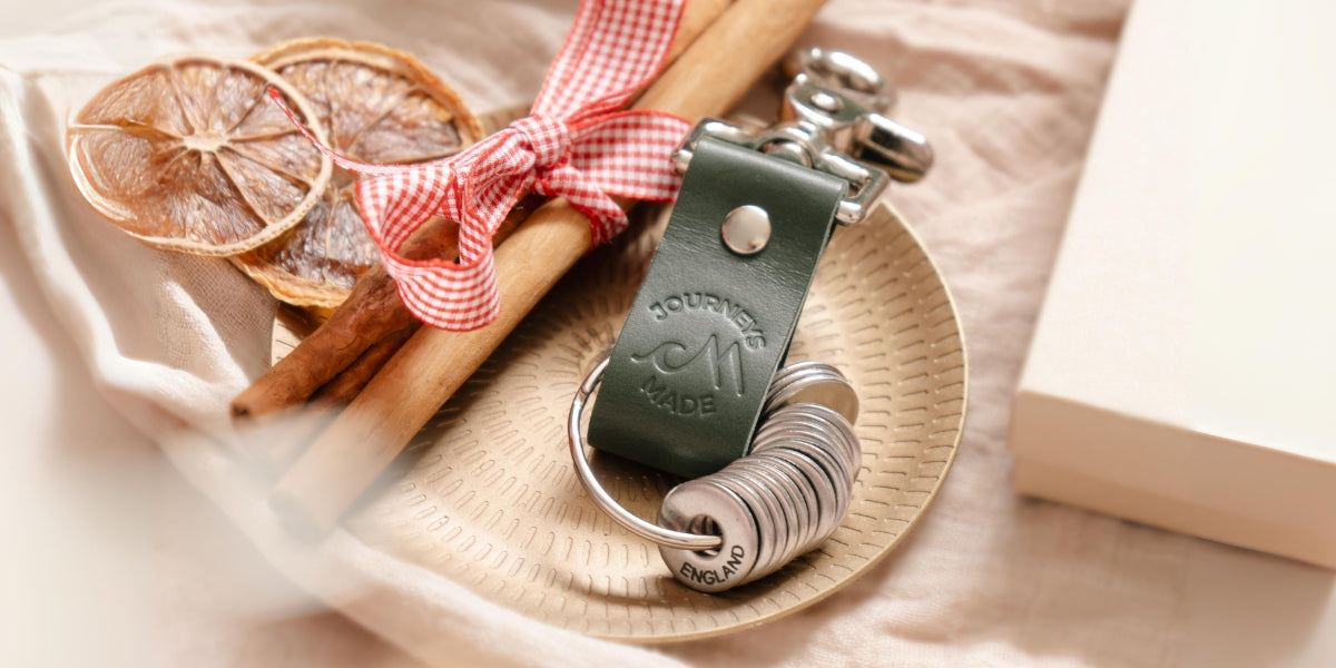 Stylish travel keyring with a green leather strap, perfect for unique travel gifts and memorable keepsakes.