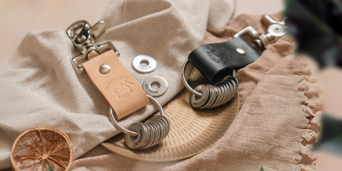 Elegant leather keyrings displayed on a textured cloth, perfect travel gifts for practical adventurers.